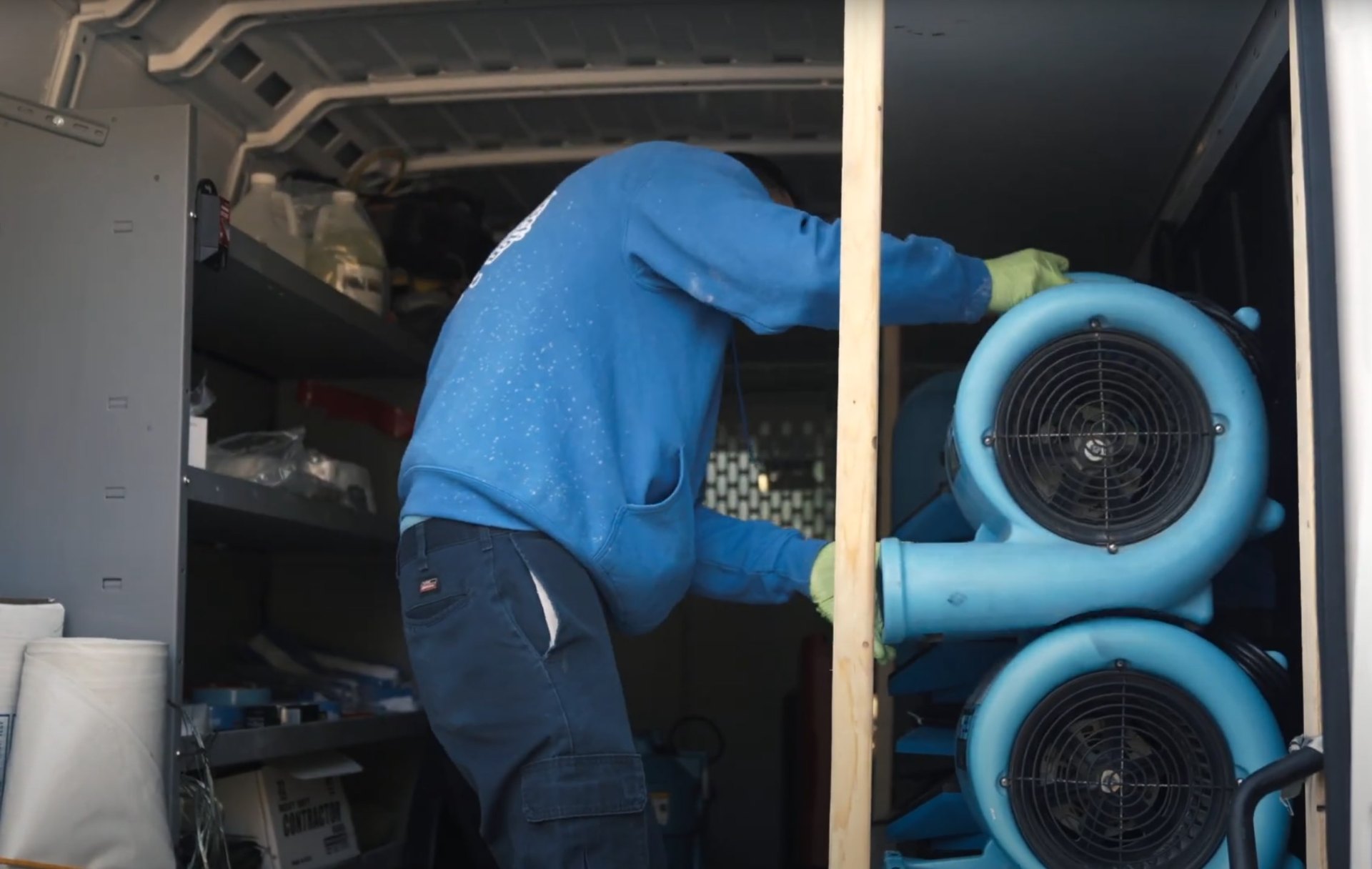 Professional water damage restoration technician working with drying equipment in Charleston basement