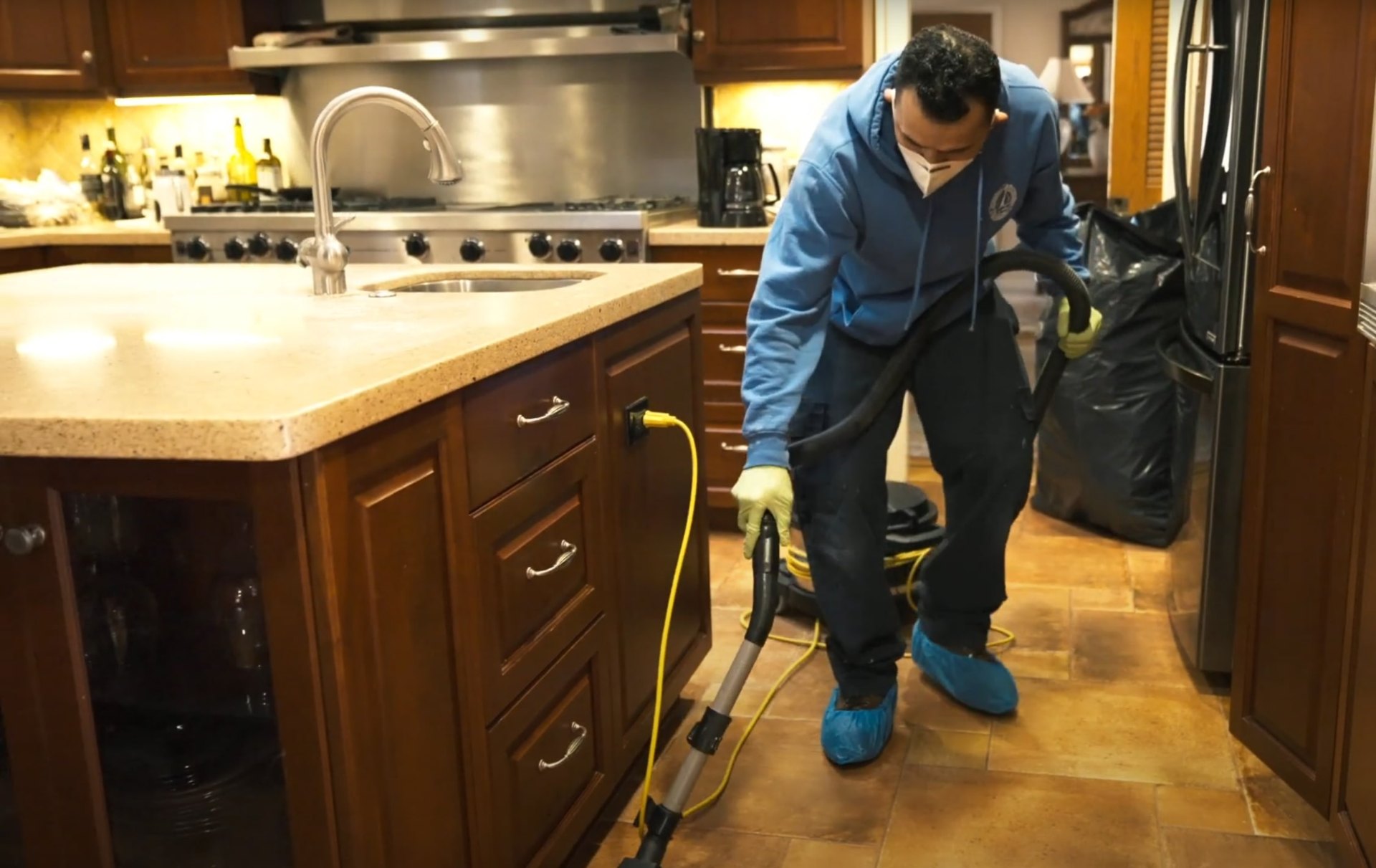 Professional water damage restoration technician using advanced water extraction equipment in a Charleston kitchen